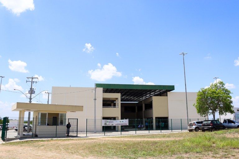 Fachada do prédio do Instituto Federal de Sergipe, em Poço Redondo. Construção clara e moderna, com guarita na entrada, portão de grades e área interna parcialmente coberta por telhado verde.