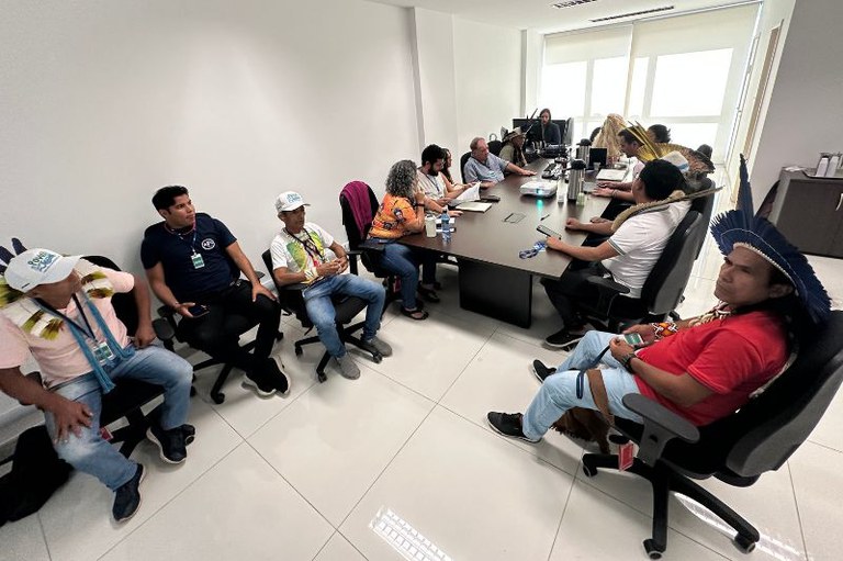 Imagem da reunião com os participantes sentados ao redor de uma mesa