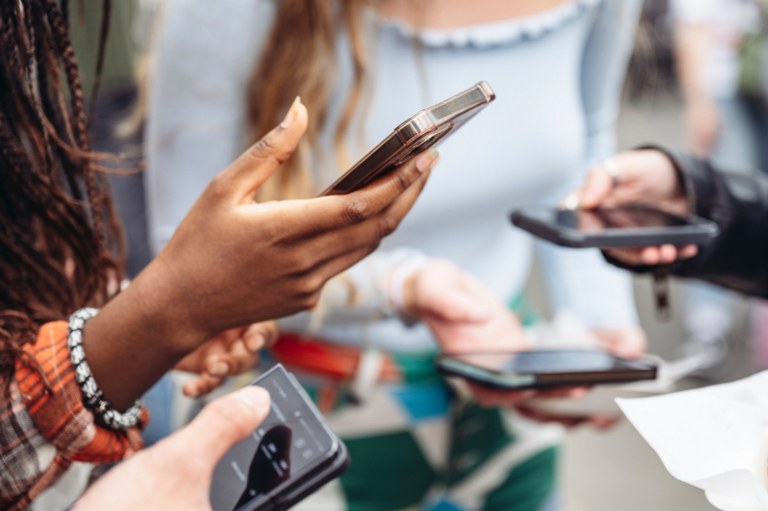 Imagem mostra grupo de pessoas utilizando celulares