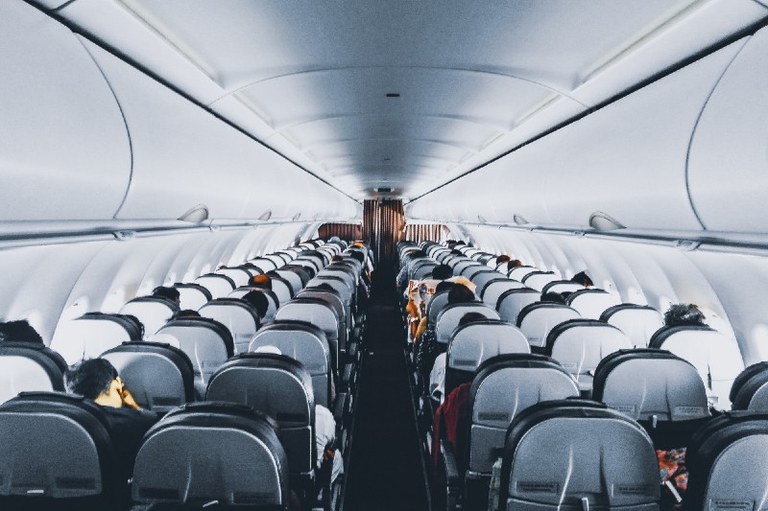 Foto mostra o corredor de um avião