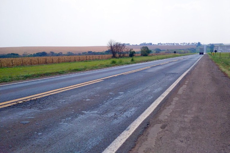 Foto mostra pista simples com buracos