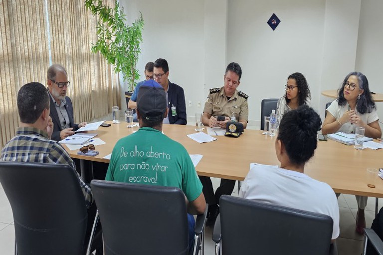 Foto mostra participantes da reunião em volta de uma mesa