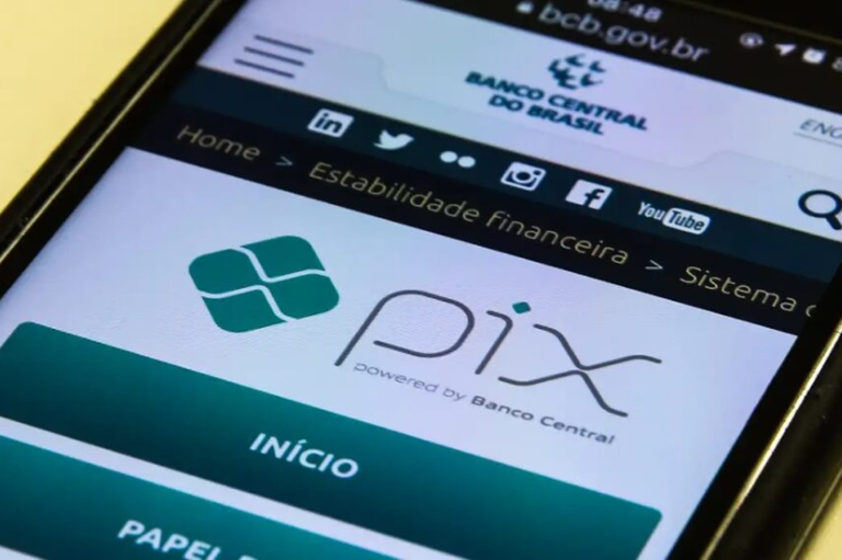 Foto em close-up de um smartphone exibindo o logotipo do Pix no site oficial do Banco Central do Brasil.