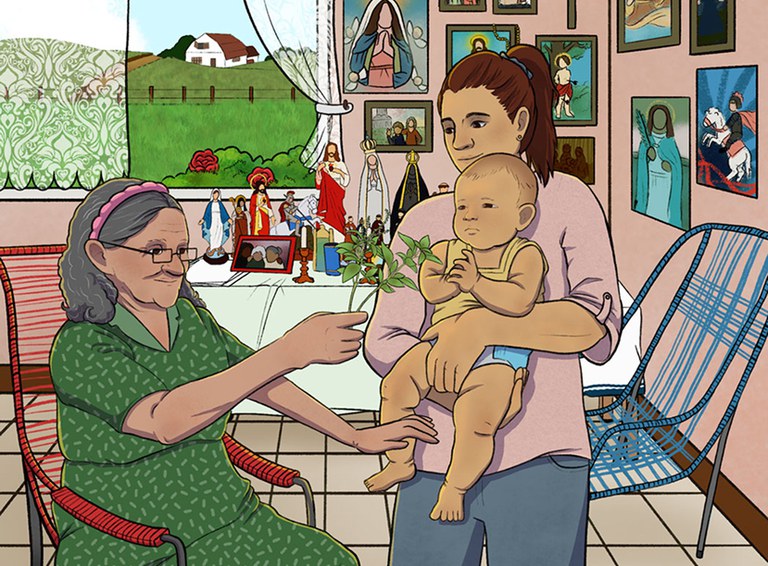 Imagem mostra uma senhora benzedeira com ramos de uma planta nas mãos. Em sua frente, há uma mulher com um bebê no colo, recebendo a benzeção.