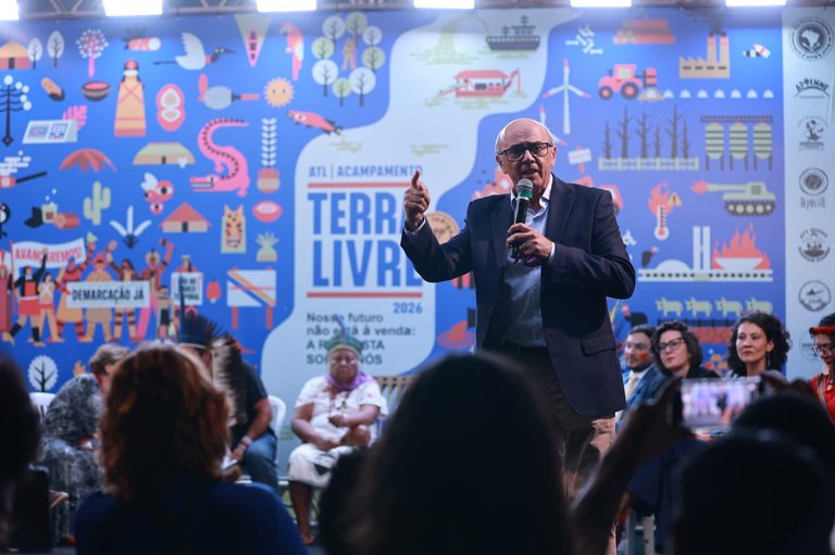 Foto de um homem com microfone na mão sobre um palco no Acampamento Terra Livre, em Brasília.