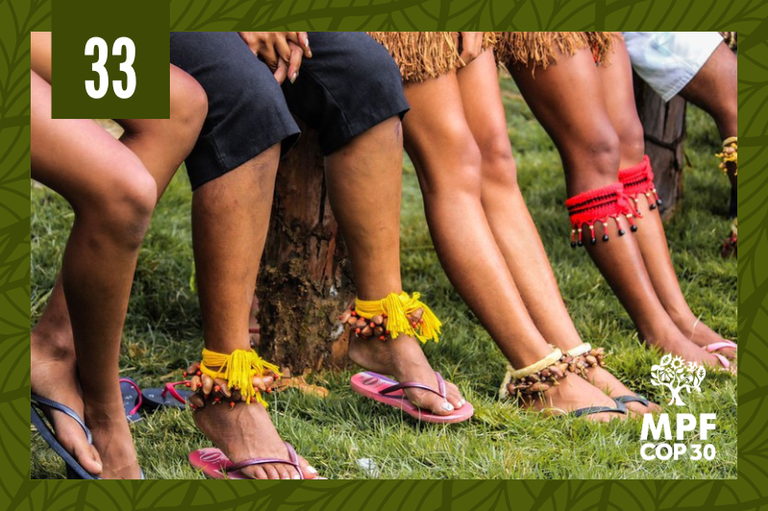 Foto em close mostra os pés adornados com ornamentos indígenas