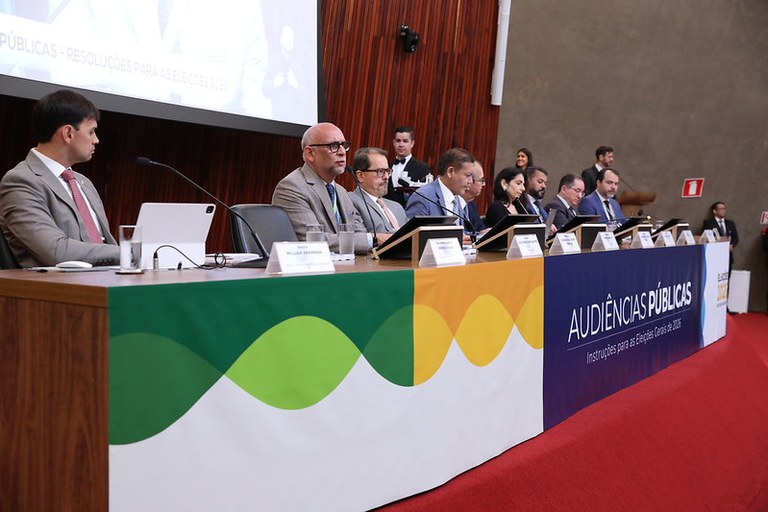 Imagem da audiência pública no TSE com o representante do MP Eleitoral falando ao microfone