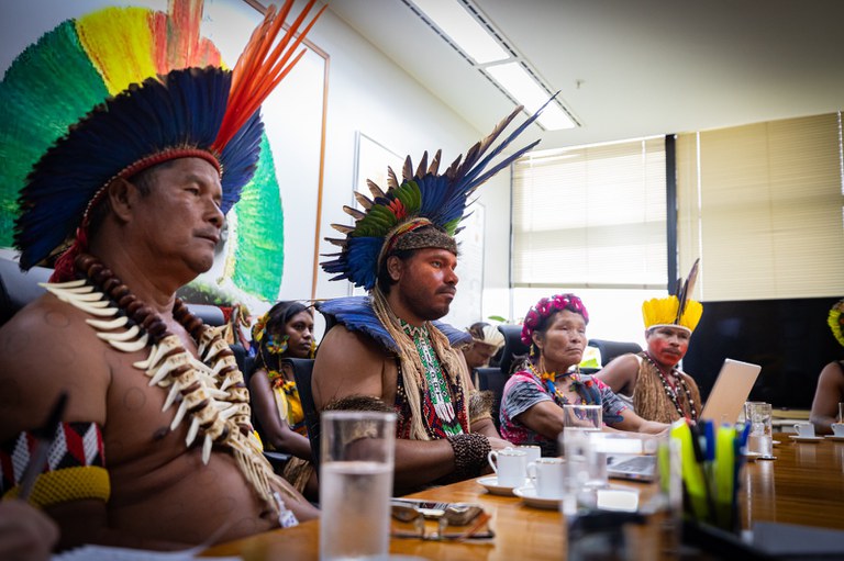 Foto mostra povos indígenas sentados à mesa