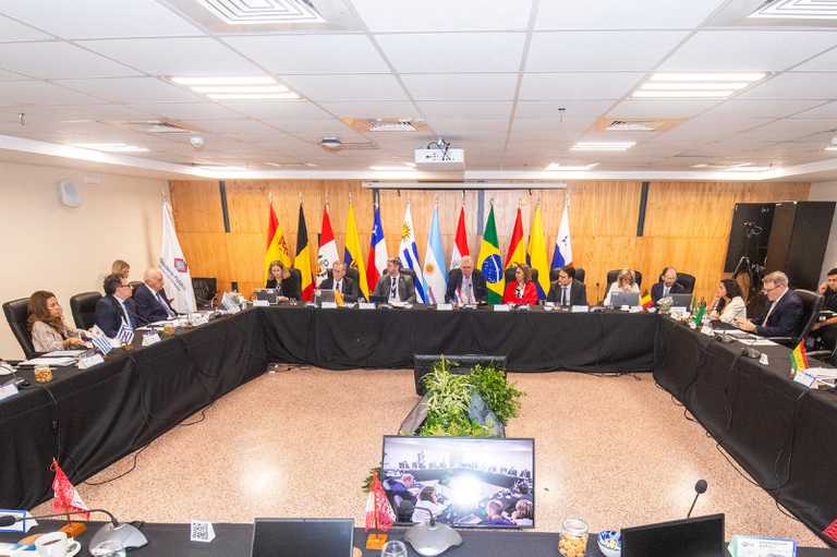 Imagem do encontro dos Ministérios Públicos do Mercosul no Paraguai, com todos os participantes sentados na mesa de reunião