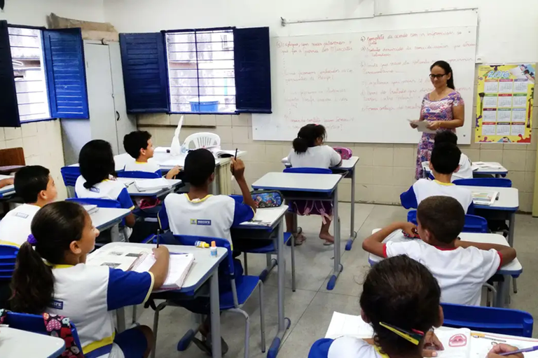 Crianças e professora em sala de aula.