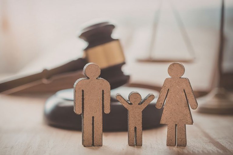 Imagem de um tribunal ao fundo com o martelo característico da Justiça e ícones de pessoas em primeiro plano