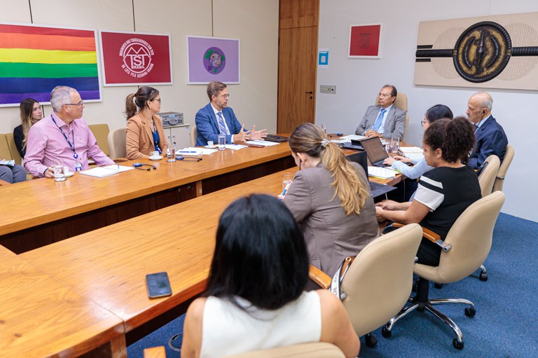 Foto de pessoas sentadas ao redor de uma mesa de reuniões
