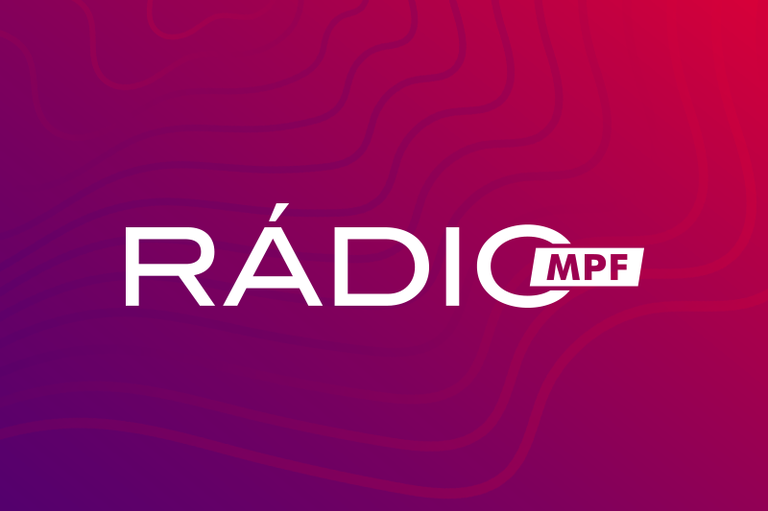 Banner mostrando o logotipo da Rádio MPF em letras brancas sobre fundo em tons de roxo e vermelho em degradê. A palavra “RÁDIO” aparece em destaque, ao centro, com o termo “MPF” inserido em um retângulo branco acoplado à letra “O”. Uma linha curva vermelha atravessa o fundo, compondo o design gráfico.