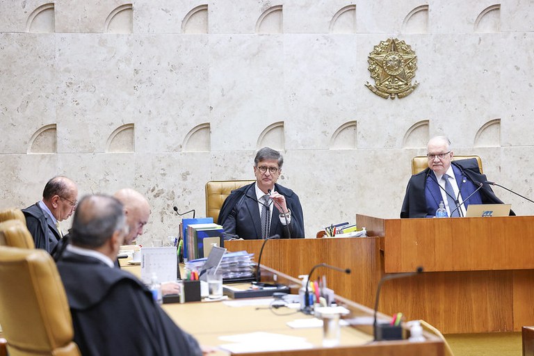 Foto do plenário do Supremo Tribunal Federal. Nela é possível ver, da direita para a esquerda, o presidente do STF, Edson Fachin, o procurador-geral da República, Paulo Gonet (que fala ao microfone), os ministros Gilmar Mendes e Alexandre de Moraes (que estão de lado)  e o ministro Flávio Dino (que está de costa ) que recebeu homenagem do presidente e do PGR no início da sessão plenária de 19 de fevereiro de 2026.