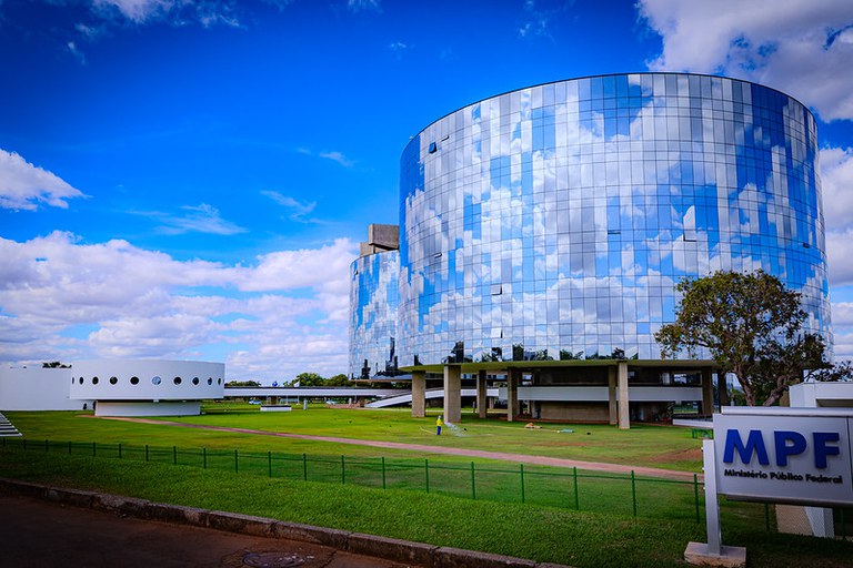 Foto dos prédio espelhados da Procuradoria-Geral da República (PGR). Ao fundo, o céu está azul entre nuvens!