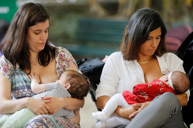 A foto original mostra duas mulheres amamentando suas respectivas crianças, A foto original é de 2018 e foi returado na Semana Mundial de Aleitamento Materno, no Palácio do Catete (RJ).