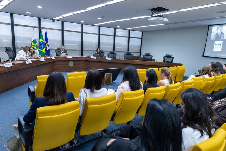 Foto do evento mostra plateia de frente para a mesa dos palestrantes com 4 pessoas