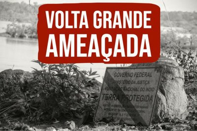 Foto em preto e branco de paisagem natural, com um rio ao fundo. À frente, uma placa oficial do Governo Federal apoiada em uma pedra. A placa traz os dizeres "Terra Protegida". Em destaque, os dizeres "Volta Grande Ameaçada" em letras brancas e fundo vermelho escuro.