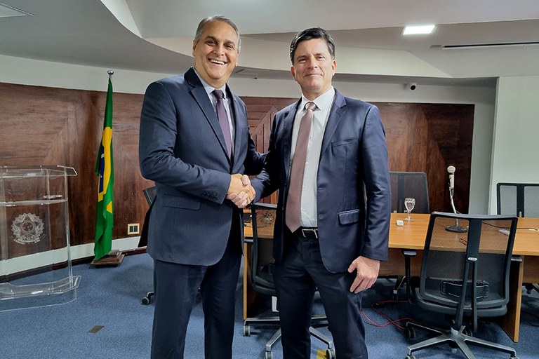 O procurador regional eleitoral Werton Costa e o procurador-geral de justiça José Paulo Xavier trocam aperto de mão no local onde houve uma reunião entre eles, que contém uma mesa de madeira e várias cadeiras.