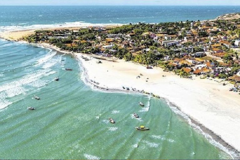 Foto aérea da vila de jericoacoara mostra a praia e as construções beira-mar