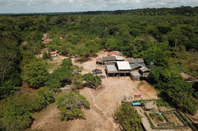 Foto aérea da comunidade Lucas, em Baião, no Pará. A foto mostra conjunto de casas simples em área de terra cercada pela floresta amazônica. Também há uma horta próxima às casas.