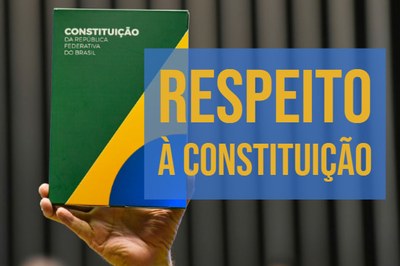 Foto mostra o livro da Constituição Federal segurada por uma mão, à esquerda, e, do lado direito, o texto "Respeito à Constituição". O texto está escrito na cor amarela sobre fundo azul.
