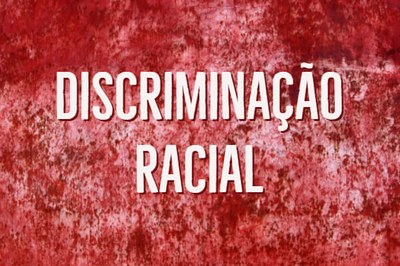 Parede vermelha com rachaduras na cor branca e rosa. Sobre a imagem foi inserido o texto "Discriminação racial" em letras grandes destacadas em vermelho.