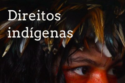 Texto Direitos indígenas sobre foto que destaca o olhar de uma pessoa indígena que usa cocar com penas que cobrem a testa