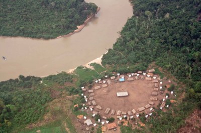 foto de aldeia indígena com oca, rodeada pela floresta. 