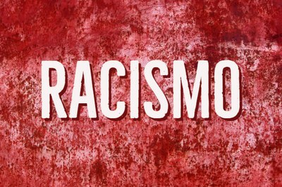 Arte retangular com a palavra "racismo" escrita em letra branca com contorno vermelho. Ao fundo, vários borrões de vermelho em fundo branco.
