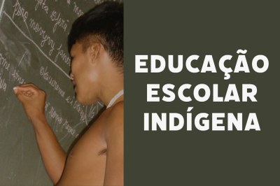 Foto de indígena. Ele escreve com giz em lousa. Ao lado direito da foto, o texto Educação Escolar Indígena.
