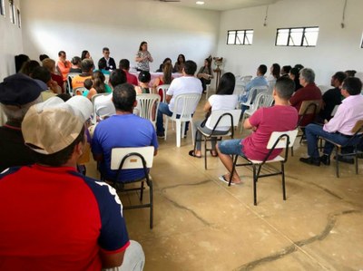 A foto mostra uma sala repleta de cadeiras em que estão sentados os participantes da reunião realizada em Monteiro (PB). Ao fundo da imagem há uma mesa composta pelos representantes dos órgãos.