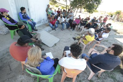Foto mostra cerca de 30 pessoas reunidas no quintal de uma casa