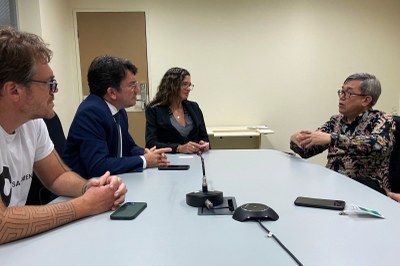 Foto do sanitarista Jack Sim sentado à mesa com dois procuradores da República, sendo um homem e uma mulher, e um representante do Instituto Ikone.