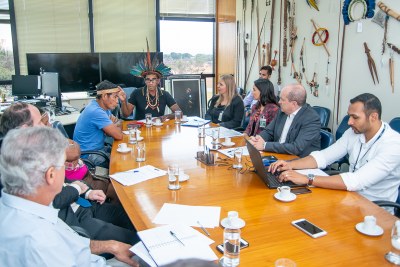 Foto mostra lideranças indígenas, representantes do Cimi e do MPF sentados à mesa durante reunião