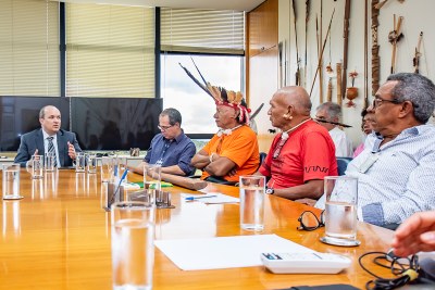 Foto mostra uma mesa de reunião, com liderança xavante e membros do MPF