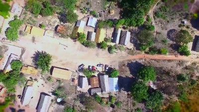 Foto aérea de uma aldeia indígena, em meio a árvores.