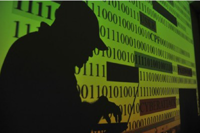 #pracegover: foto exibe a sombra de uma pessoa sobre uma tela de computador ampliada com vários dados