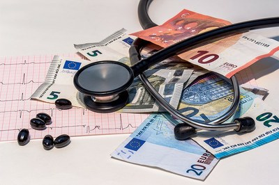 Imagem ilustrativa mostra medicamentos, exames médicos e estetoscópio misturados a notas de dinheiro