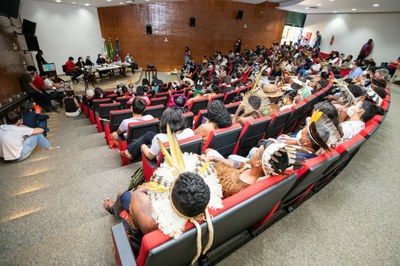 Foto de indígenas em um auditório assistindo à palestra 