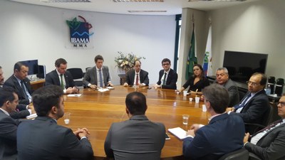 Foto mostra os participantes da reunião sentados em torno de uma grande mesa redonda