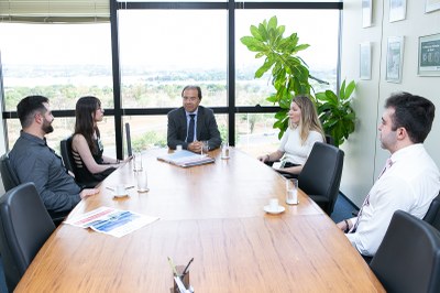 Foto mostra uma reunião, em que pessoas estão conversando