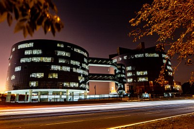 Foto noturna dos prédios que abrigam a procuradoria-geral da república em brasília. Os prédios são redondos, interligados e revestidos de vidro que reflete a luz interna.
