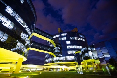 Foto noturna dos prédios que abrigam a procuradoria-geral da república, em brasília. São dois prédios redondos, interligados e revestidos de vidro. Os prédios recebem iluminação amarela.