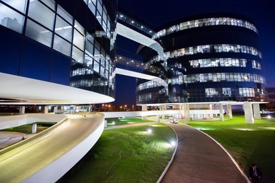 Foto noturna dos prédios que abrigam a procuradoria-geral da república, em Brasília. Os dois prédios são redondos, interligados e revestidos de vidro.
