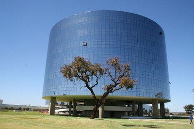 Foto de um dos prédios da PGR. À frente do edifício, tem uma árvore típica do cerrado.