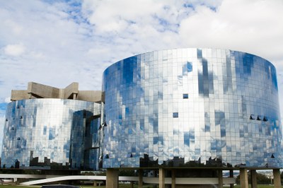Foto dos prédios da PGR em dia com o céu carregado de nuvens, que refletem nos vidros dos edifícios