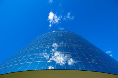 #pracegover: foto de detalhe de um prédio redondo, recoberto de vidro, que reflete o azul do céu. a foto é de Antonio Augusto, da Secretaria de Comunicação do Ministério Público Federal.