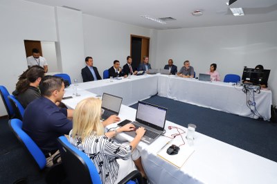 Foto da reunião com os participantes sentados em uma mesa em U