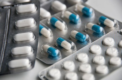 Foto ilustrativa mostra cartelas de medicamentos na cores branco e azul.